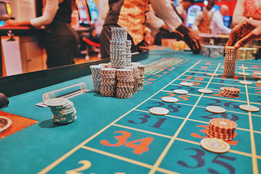 A blue table with numbers and chips with players in the periphery