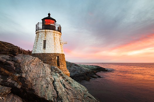 Castle Hill Lighthouse at sunset showing the rocky landscape